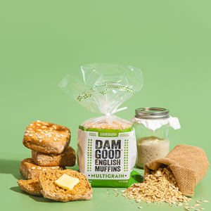 English muffins, sourdough package, and jar on a green background